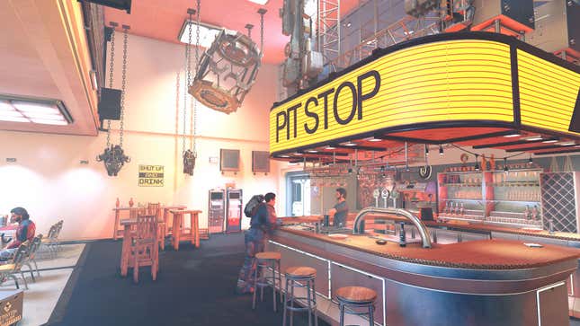 A few patrons in the Pit Stop bar, which features hanging spaceship parts and bright lighting. 